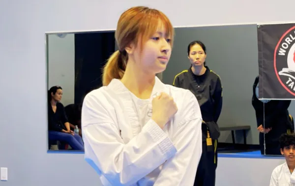 Teen student in a blocking stance during class